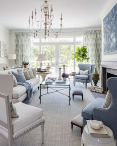 a living room filled with lots of furniture and a chandelier hanging from the ceiling