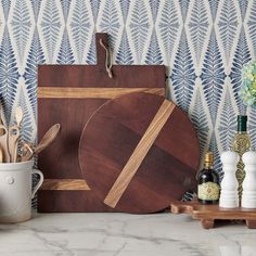 a wooden cutting board sitting on top of a counter next to a cup and saucer