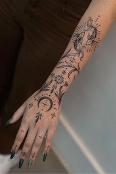 a woman's hand with tattoos on her left arm and the sun and moon