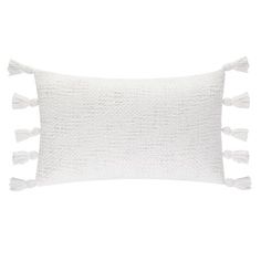 a white pillow with tassels on it