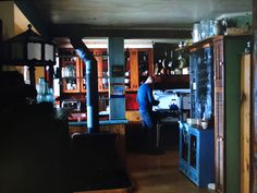 a man standing in the middle of a kitchen with lots of cupboards and shelves