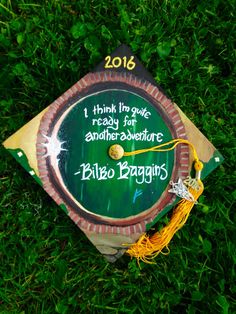 a graduation cap that has been placed on the grass for someone to write their name