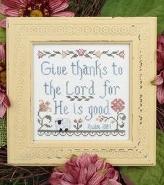 a cross stitch pattern with pink flowers and green leaves in front of the frame that says give thanks to the lord for he is good