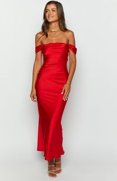 a woman wearing a red dress with one shoulder and an off the shoulder slited top