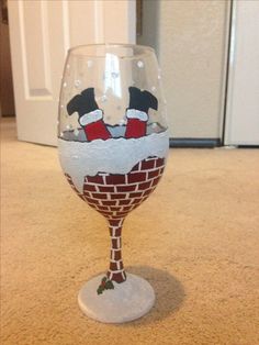 a wine glass decorated with an image of santa clause on the bottom and chimney design