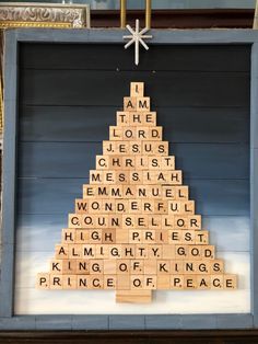 a christmas tree made out of scrabble tiles in a frame on the wall