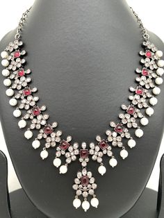 CZ Pink Stone Pearls Victorian Finish Short Neckalce with Matching EarringsColor : GoldenSize : Necklace Length : 16 Inches; Earring Length : 2 inchesStones : Pink Stone CZ Pearls