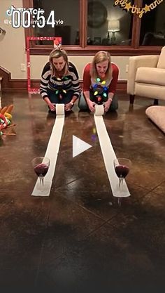 two girls are playing with wine glasses on the floor