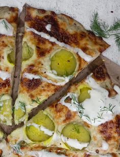 a pizza with cheese and pickles on it