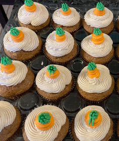 cupcakes with white frosting and orange decorations