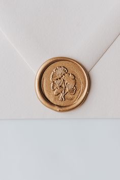 an envelope with a wax stamp on it and a flower in the middle is shown