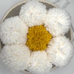 a white plate topped with yellow and white pom - poms