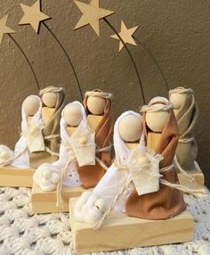 three wooden dolls are sitting on top of a white table cloth with stars in the background