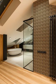 a bathroom with a large white bath tub next to a wooden floor