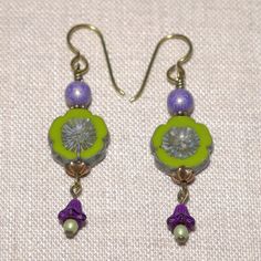 Adorned By Lily Green & Purple Czech Glass Flower Long Earrings With Hypoallergenic Anodized Niobium Ear Wires Green Table-Cut Pressed Czech Glass Flower Beads Are Accented With Lavender & Green Czech Glass Druk & Purple Pressed Bell Flower Czech Glass Beads Antiqued Solid Bronze Eye Pins, Antiqued Solid Brass Headpins, And Copper Plated Lead-Free Pewter Bead Caps & Daisy Spacers Hypoallergenic Anodized Niobium Ear Wires Length (Excluding Ear Wires): 1 5/8” Includes Silicone Ear Nuts To Help Pre Glass Flower Earrings, Lily Jewelry, Lavender Earrings, Feminine Earrings, Lavender Green, Vintage Style Earrings, Jewelry Boutique, Artisan Earrings, Purple Earrings