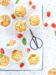 some muffins are on a tray with tomatoes and other toppings around them