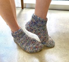 the legs of a person wearing socks with multicolored knits on them, standing in front of a door