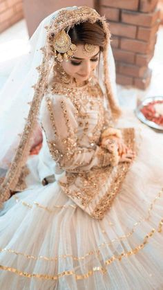 a woman in a wedding dress sitting on the floor