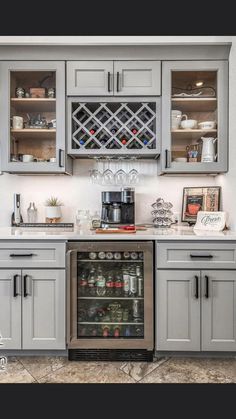 a kitchen with gray cabinets and glass shelves on the wall above the stove is filled with wine glasses