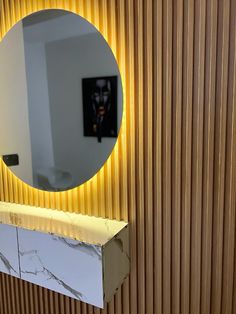 a bathroom with a round mirror on the wall next to a sink and counter top