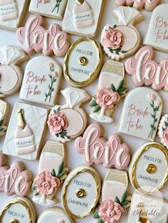 decorated cookies are arranged on a table with pink and gold decorations, including roses, perfume bottles, and love letters