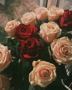 a bouquet of roses sitting in front of a window