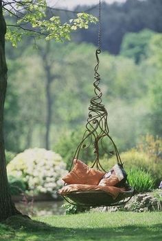 a tree swing hanging from a tree in a park