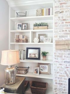 a living room filled with lots of white shelves and baskets on top of each shelf