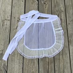 a piece of white lace on top of a wooden floor