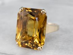 "This is a classic piece from the 1970s! The tab prongs and open-work style setting brings a wonderful sense of light and movement to the bright golden yellow citrine that we've set at the center! This big, bold, and color-filled stone is sure to be a conversation starter! Metal: 14K Yellow Gold Gem: Citrine 22.10 Carats Gem Measurements: 19.5 x 15.3 mm, Cushion Cut Ring Size: 6.50 Marks: \"14K\" Stamped on the inside band SKU #: A1464 Each piece has been identified and graded by a Graduate Gemo Rose Gold Halo Ring, Opal Solitaire Ring, Halo Band, Rose Gold Halo, Floral Engagement Ring, Citrine Jewelry, Pearl And Diamond Ring, Sapphire Solitaire, Cushion Cut Ring