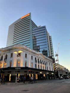 the building is very tall and has many windows on it's sides, as well as people walking around