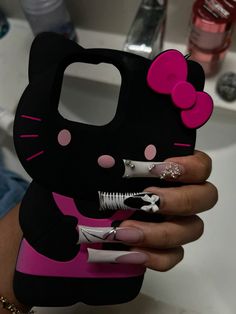 a person holding a hello kitty phone case in their hand with nail polish on it