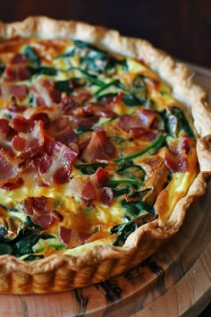 a bacon and spinach quiche on a wooden platter