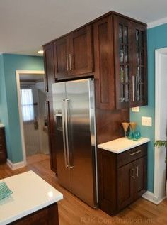 a kitchen with blue walls and wooden cabinets