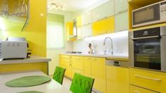 a kitchen with yellow cabinets and green chairs