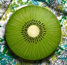 a green kiwi plate sitting on top of a bed