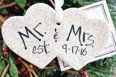 two ceramic hearts with the names mr and mrs on them hanging from a christmas tree