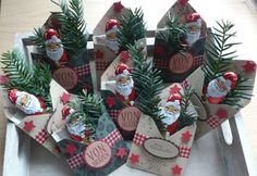 small christmas gift bags on a tray with pine branches and santa's hat decorations