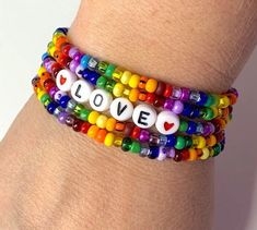 So wonderful to look at and fun to wear! This is a set of 5 brightly colored rainbow seed bead bracelets and one of them has the word LOVE. Each light weight, strong, stretchy. Easy to wear. Can be made to fit you perfectly in child through adult sizes. Beads may vary slightly from the ones shown. Purchasing this listing, you will get 5 strands of seed bead bracelets as seen in the 1st picture. This is a special NON personalized price. This listing is for 1 set of 5 bracelets all the same size. Pony Bead Bracelets, Preppy Bracelets, Love Word, Pride Bracelet, Memorial Bracelet, Beads Bracelet Design, Jewelry Making Necklace, Rainbow Bracelet, Love And Pride