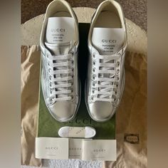 This Is A Pair Of Authentic Silver Metallic Leather Gucci Sneakers New In Box Men’s Size 7 Or Women’s Size 9.5/10 New In Box Thanks For Stopping By! Classic Gucci Sneakers With Embossed Logo, Luxury Gucci Sneakers, Gucci Designer Calf Leather Sneakers, Gucci Designer Sneakers For Formal Occasions, Gucci Designer Formal Sneakers, Gucci Ace Sneakers, Gucci Shoes Sneakers, Men's High Top Sneakers, Gucci Sneakers