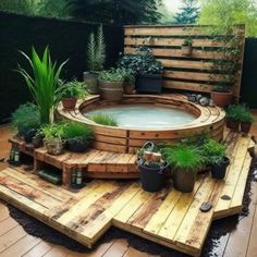 an outdoor hot tub surrounded by potted plants and wooden pallets on the floor