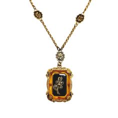 Behold this splendid Victorian revival necklace from the 1930s, adorned with orange and black glass elegantly encased in brass. The floral design exudes a delicate and distinctly feminine charm, a prevailing characteristic of its time. The tiny imitation seed pearls add charm, and the back is engraved with the monogram MLM. The necklace is in very good vintage condition with minimal signs of wear. The glass's surface shows fine lines but nothing distracting. The brass chain is not damaged, and t Vintage Black Enamel Rectangular Jewelry, Orange Victorian Jewelry For Formal Occasions, Vintage Rectangular Black Enamel Jewelry, Vintage Black Enamel Necklace For Evening, Vintage Black Enamel Necklaces For Evening, Vintage Black Enamel Necklace For Formal Occasions, Vintage Black Enamel Necklaces For Formal Occasions, Antique Gold Necklaces With Black Enamel, Antique Black Enamel Necklace For Formal Occasions