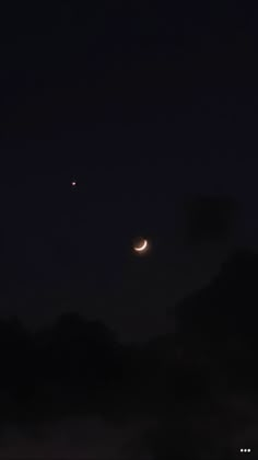 two crescents are seen in the night sky with clouds and dark skies behind them