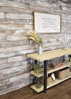 a wooden wall with a sign above it and some plants in baskets on the bottom shelf