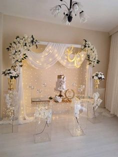 a wedding cake is displayed in clear acrylic cases with flowers and lights around it