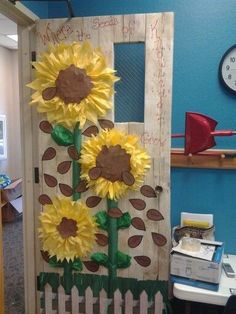 a door decorated with sunflowers in the middle of a room next to a desk