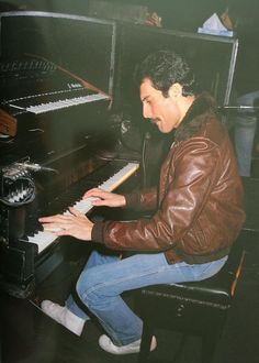 a man sitting at a piano with his hands on the keys