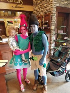 a man and woman in costumes standing next to each other with a baby in a stroller