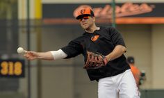 a baseball player is throwing a ball in the air with his arm extended and wearing a catchers mitt