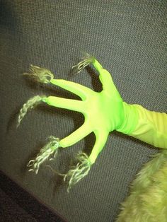 a person wearing neon green gloves laying on top of a couch